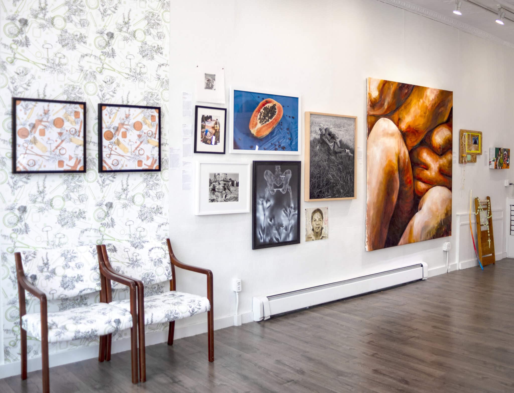 Body-based artwork covers the wall of a gallery.